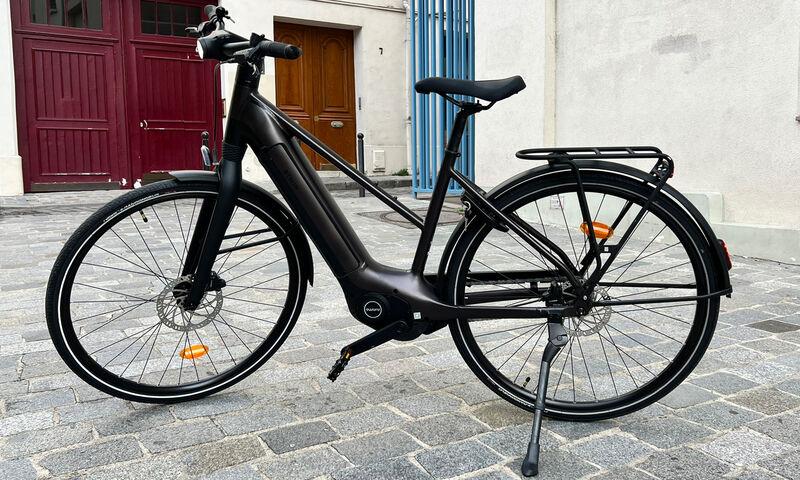 Un vélo électrique Btwin garé dans une ruelle